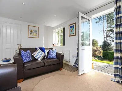 a living room with a couch and a sliding glass door at The Lodge in Carlyon Bay