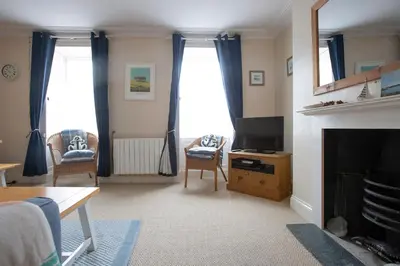 a living room with a television and a fireplace at Elegant 2 bed in the heart of Falmouth - sleeps 4 in Falmouth