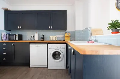 a kitchen with a washing machine and a sink at Elegant 2 bed in the heart of Falmouth - sleeps 4 in Falmouth