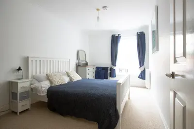 a bedroom with a bed and a dresser and a window at Elegant 2 bed in the heart of Falmouth - sleeps 4 in Falmouth