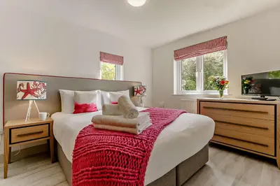 a bedroom with a large bed with a red blanket at 2 Bed in St. Ives oc-92928 in Carbis Bay