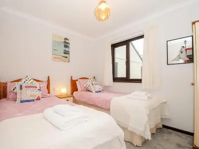 a bedroom with two beds and a window at St Albans in Boscastle