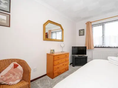 a bedroom with a bed and a mirror and a television at St Albans in Boscastle