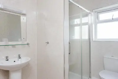 a bathroom with a shower and a sink and a toilet at Barrowfield Hotel in Newquay