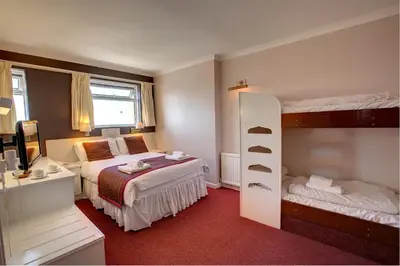 a bedroom with two bunk beds and a desk at Barrowfield Hotel in Newquay