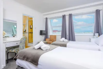 a hotel room with two beds and a piano at Barrowfield Hotel in Newquay