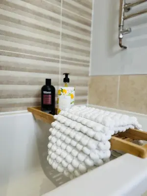 a pile of white towels sitting on a bath tub at Private Double Room with Ensuite, No Breakfast, Truro City Centre in Truro