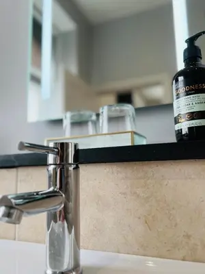 a bottle of soap sitting on a counter next to a sink at Private Double Room with Ensuite, No Breakfast, Truro City Centre in Truro