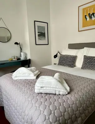 a bedroom with a bed with two towels on it at Private Double Room with Ensuite, No Breakfast, Truro City Centre in Truro