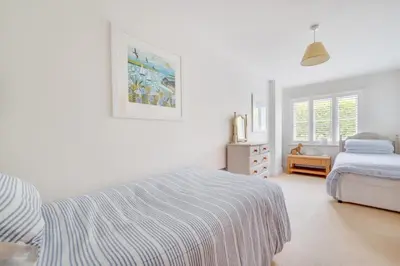 a white bedroom with a bed and a dresser at 2 Bed in Wadebridge oc-p00374 in Wadebridge