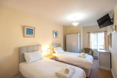 a room with two beds with towels on them at Chymoresk - Self Catering Holiday Cottage Hayle St Ives Bay in Hayle