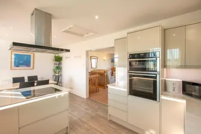 a kitchen with white cabinets and a counter top at Chymoresk - Self Catering Holiday Cottage Hayle St Ives Bay in Hayle