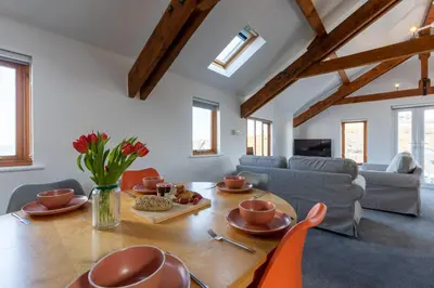 a living room with a table and a couch at Sunset View in Bude