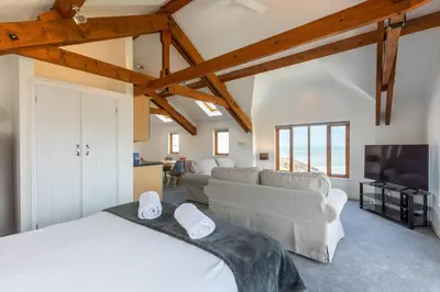 a bedroom with a white bed and a tv at Sunset View in Bude