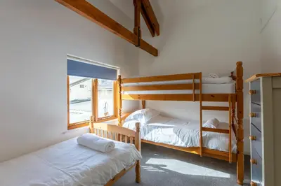 two bunk beds in a room with a window at Sunset View in Bude