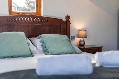a bedroom with a bed with green pillows on it at Sunset View in Bude