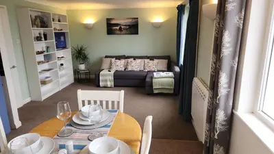 a living room with a table and a couch at Top Location Perranporth Apartment in Perranporth