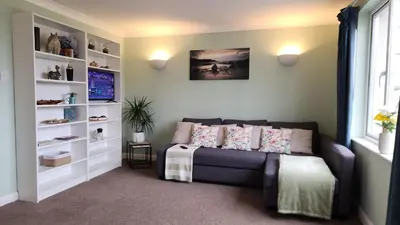 a living room with a couch and a window at Top Location Perranporth Apartment in Perranporth