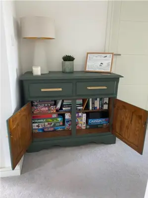 a green cabinet with books on it in a room at Sunny Eco Home minutes from the beach (Tamsin) in Newquay