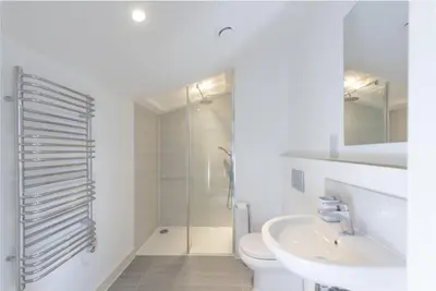 a white bathroom with a toilet and a sink at Sunny Eco Home minutes from the beach (Tamsin) in Newquay