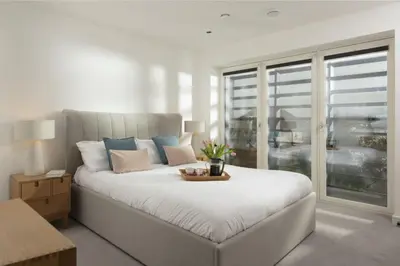 a bedroom with a large white bed and a window at Sunny Eco Home minutes from the beach (Tamsin) in Newquay
