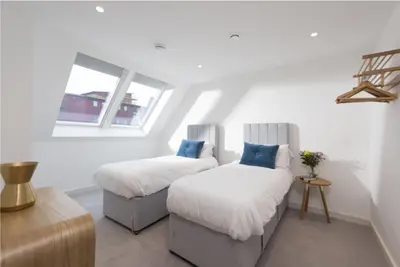 a bedroom with two beds and a window at Sunny Eco Home minutes from the beach (Tamsin) in Newquay