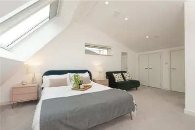a bedroom with a bed and a chair at Sunny Eco Home minutes from the beach (Tamsin) in Newquay
