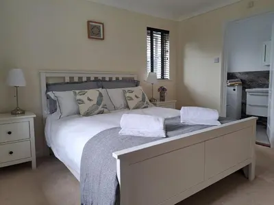 a bedroom with a white bed with two towels on it at Trevallion in Saint Endellion