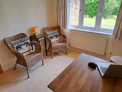 a living room with two chairs and a table at Trevallion in Saint Endellion