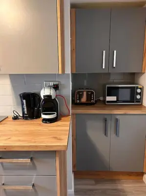 a kitchen with a counter top with a microwave and appliances at Waves Cottage, Newquay. in Newquay