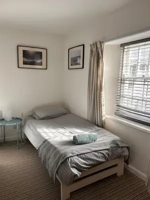 a bed in a bedroom with a window at Waves Cottage, Newquay. in Newquay