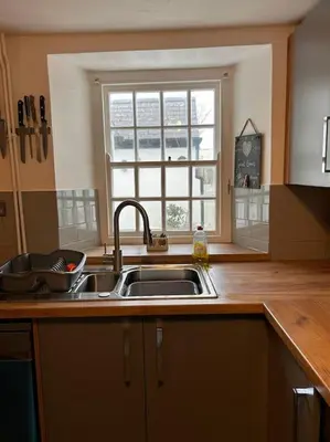 a kitchen with a sink and a window at Waves Cottage, Newquay. in Newquay