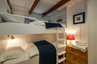 a bedroom with two bunk beds and a lamp at Sea Horses in Port Isaac