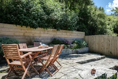 a wooden table and chairs sitting on a patio at Sea Horses in Port Isaac