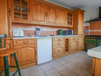 a kitchen with wooden cabinets and a white dishwasher at Eden Retreat in Par