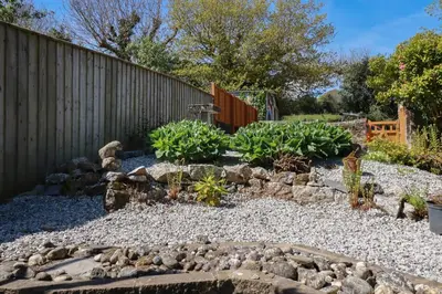 a garden with rocks and plants in front of a fence at Eden Retreat in Par