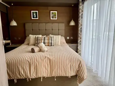 a bedroom with a large bed with two stuffed animals on it at Holywell Lodge in Newquay