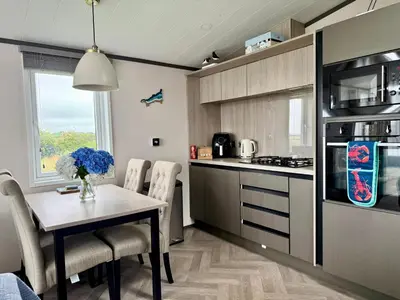 a kitchen with a table and chairs in a kitchen at Holywell Lodge in Newquay