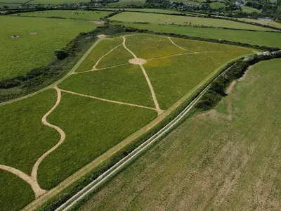 an aerial view of a field with a dirt road at Holywell Lodge in Newquay