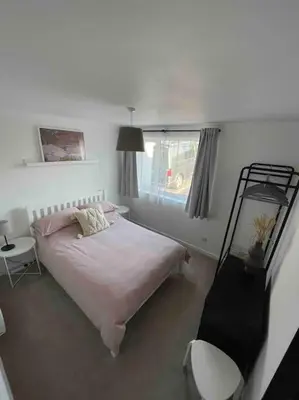 a bedroom with a bed and a window at Peaceful centrally located, 2 Bedroom Bungalow. in Camborne