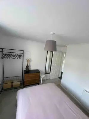 a bedroom with a bed and a dresser and a mirror at Peaceful centrally located, 2 Bedroom Bungalow. in Camborne