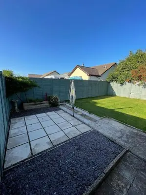 a patio with an umbrella in a yard at Peaceful centrally located, 2 Bedroom Bungalow. in Camborne