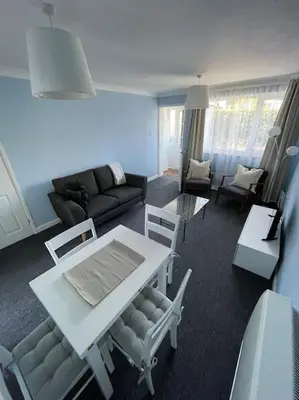 a living room with a white table and chairs at Peaceful centrally located, 2 Bedroom Bungalow. in Camborne