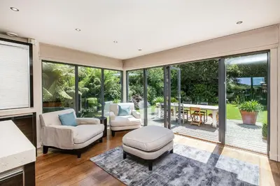 a living room with chairs and a table and windows at Moonfleet in Saint Mawes