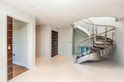 a metal spiral staircase in a room with a closet at Moonfleet in Saint Mawes