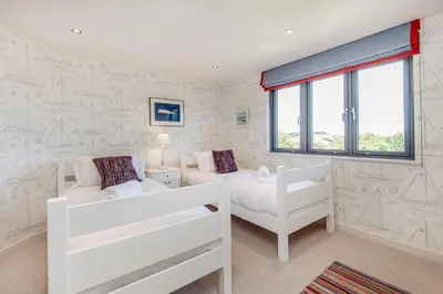 a bedroom with two white beds and a window at Moonfleet in Saint Mawes