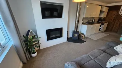a living room with a couch and a fireplace at Pepperpot in Portreath