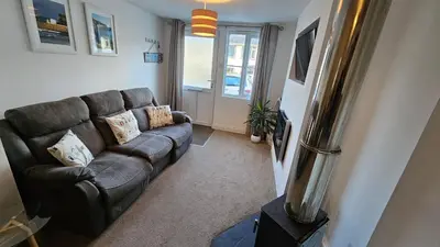 a living room with a couch and a window at Pepperpot in Portreath