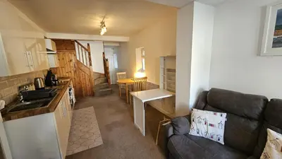a kitchen and a living room with a couch at Pepperpot in Portreath