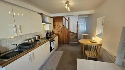 a kitchen with a sink and a table in it at Pepperpot in Portreath
